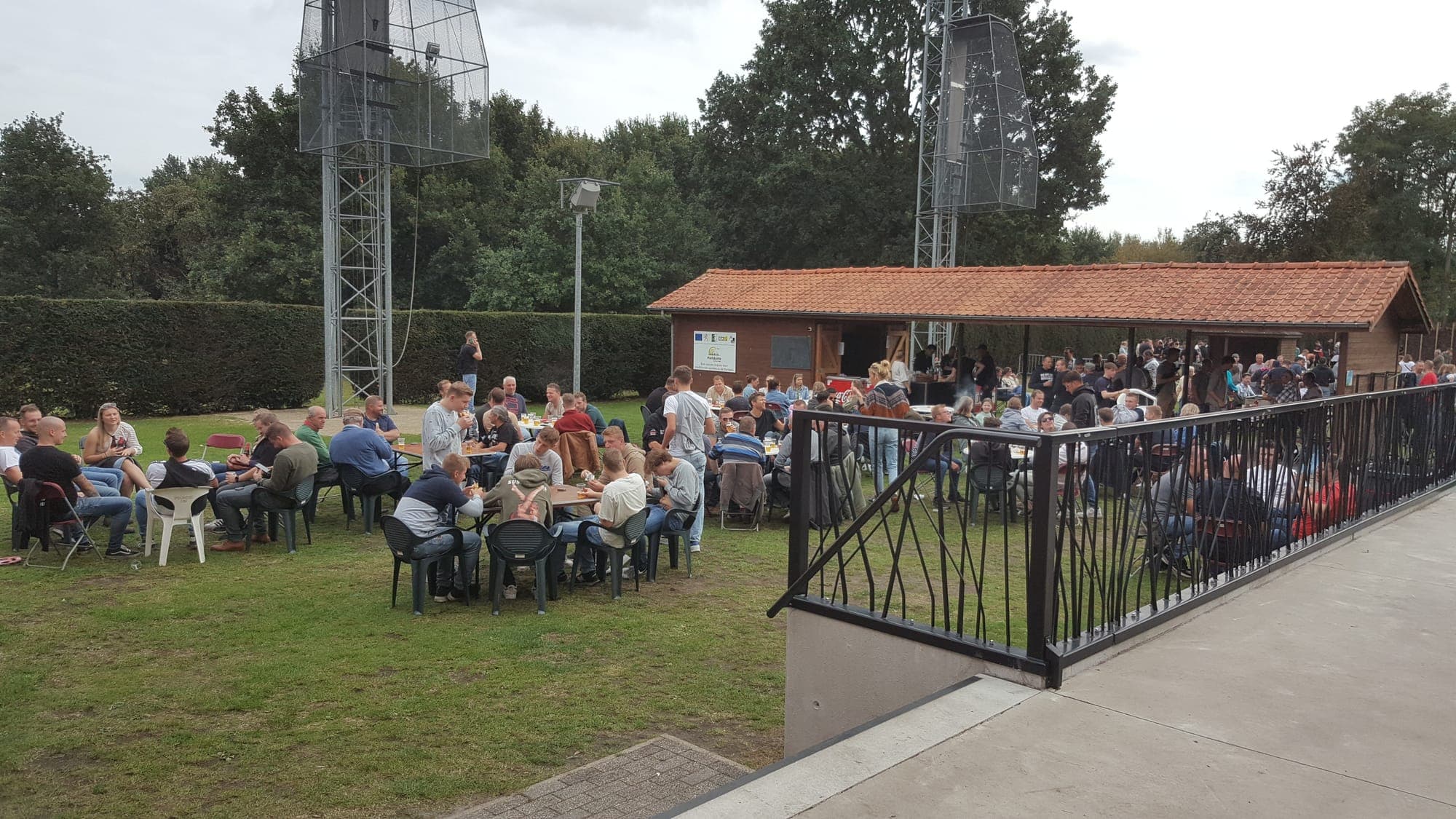 Gasten aan tafels op het terras en in de tuin
