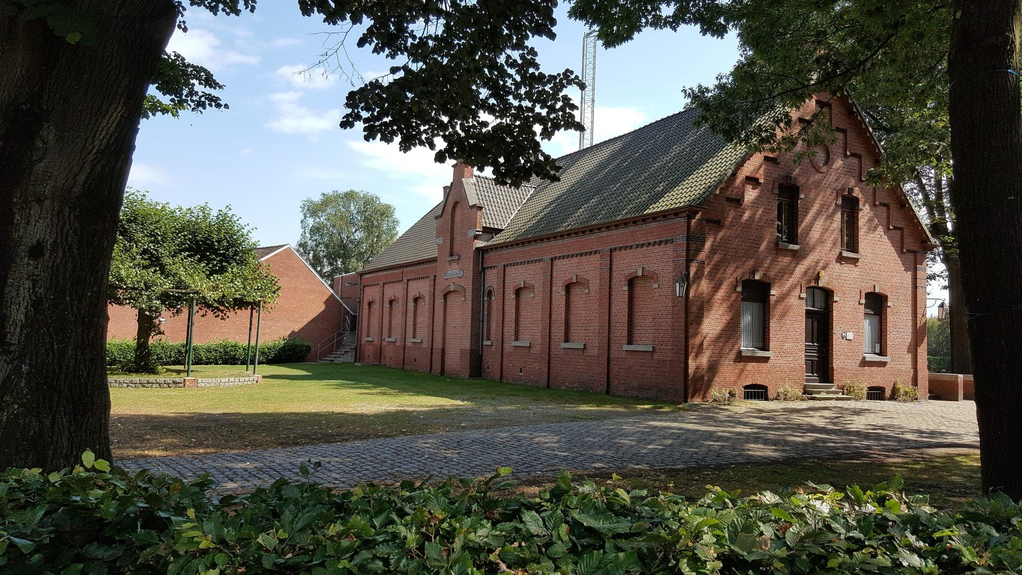 De voorgevel van zaal De Kunstvrienden met de oprit